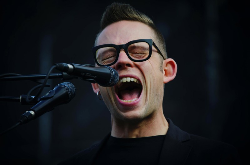 shallow focus photography of man shouting using microphone